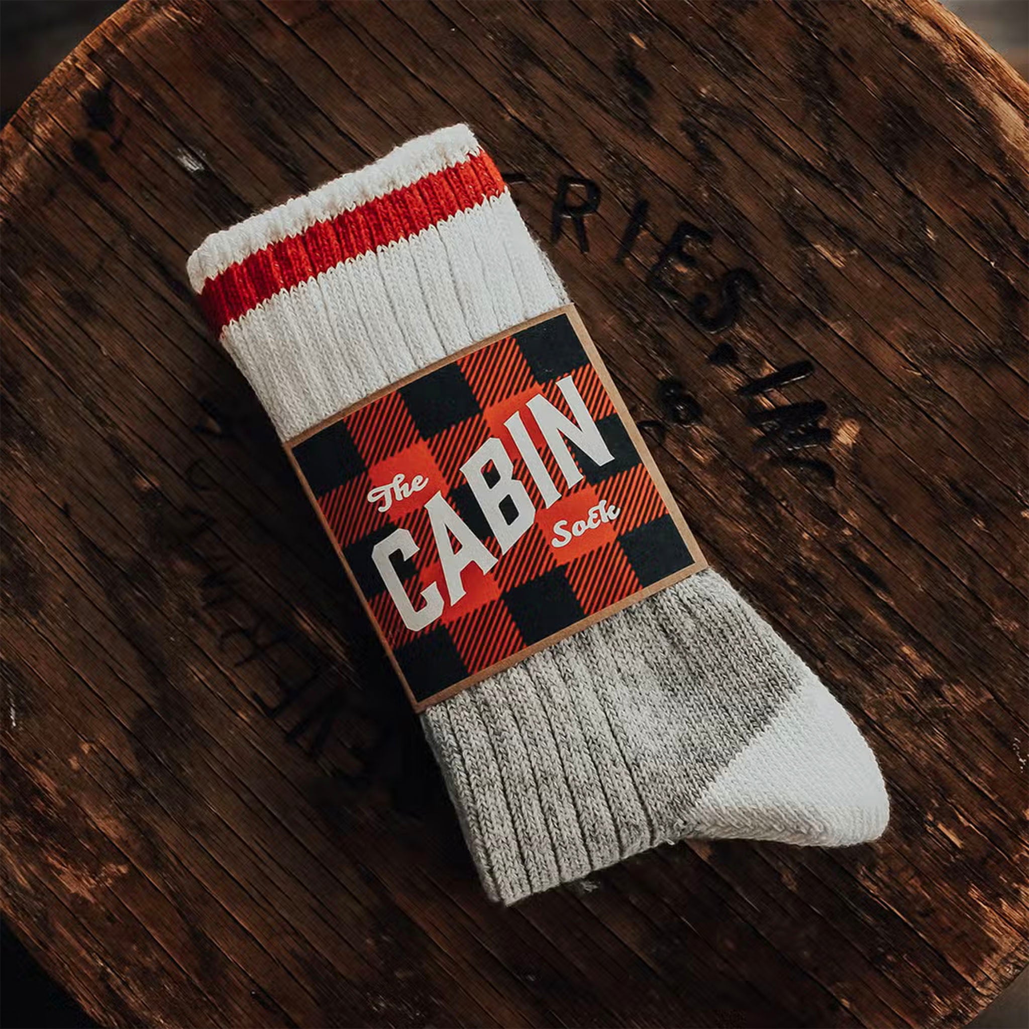 Grey and white recycled wool 'cabin socks' on a wood surface