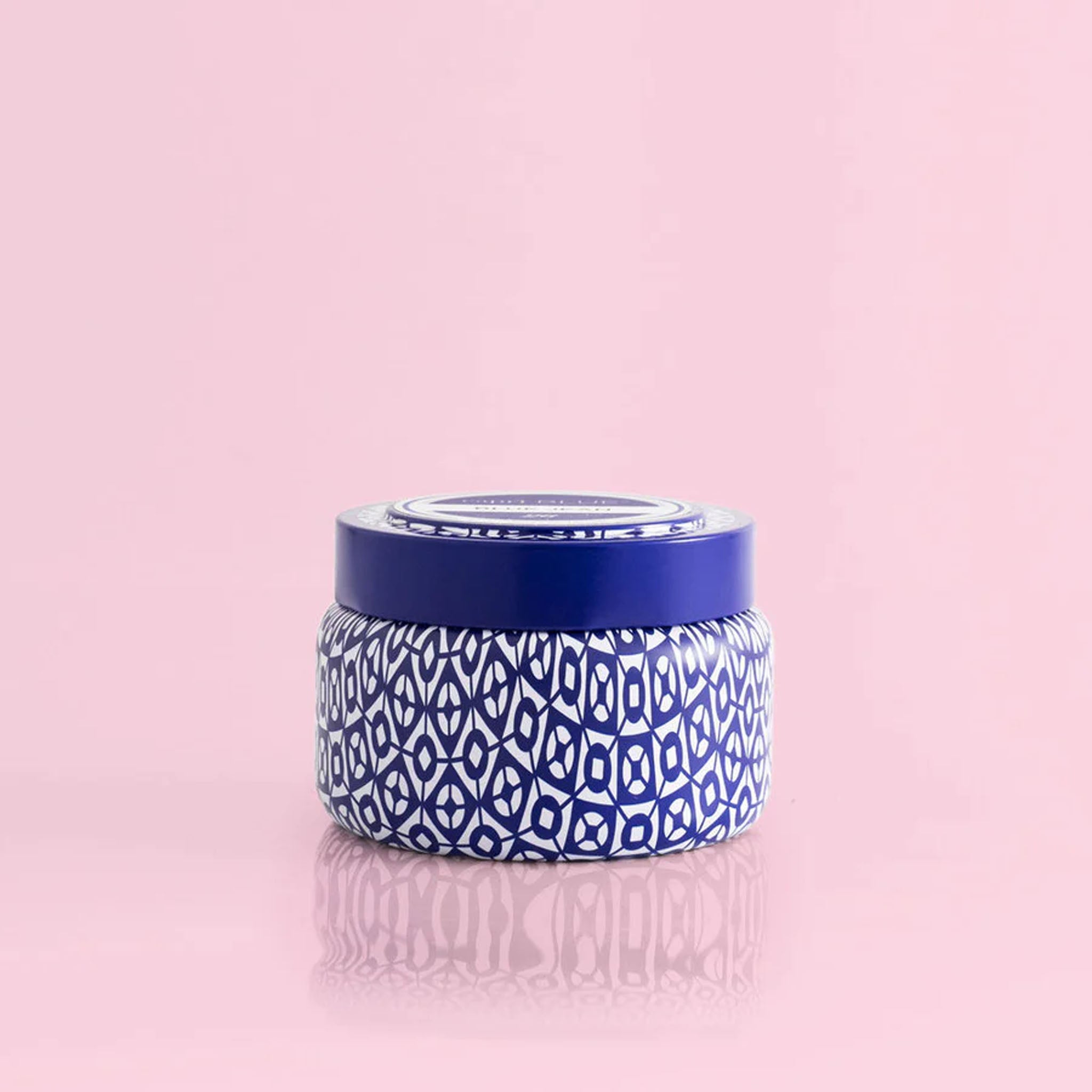 Capri Blue Volcano Signature Printed Travel Tin Candle on a pink background