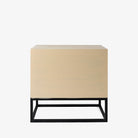 Cabinet with two drawers in white washed wood and black metal base on a white background