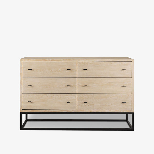 White washed wood six drawer dresser with metal base on a white background