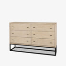 White washed wood six drawer dresser with metal base on a white background
