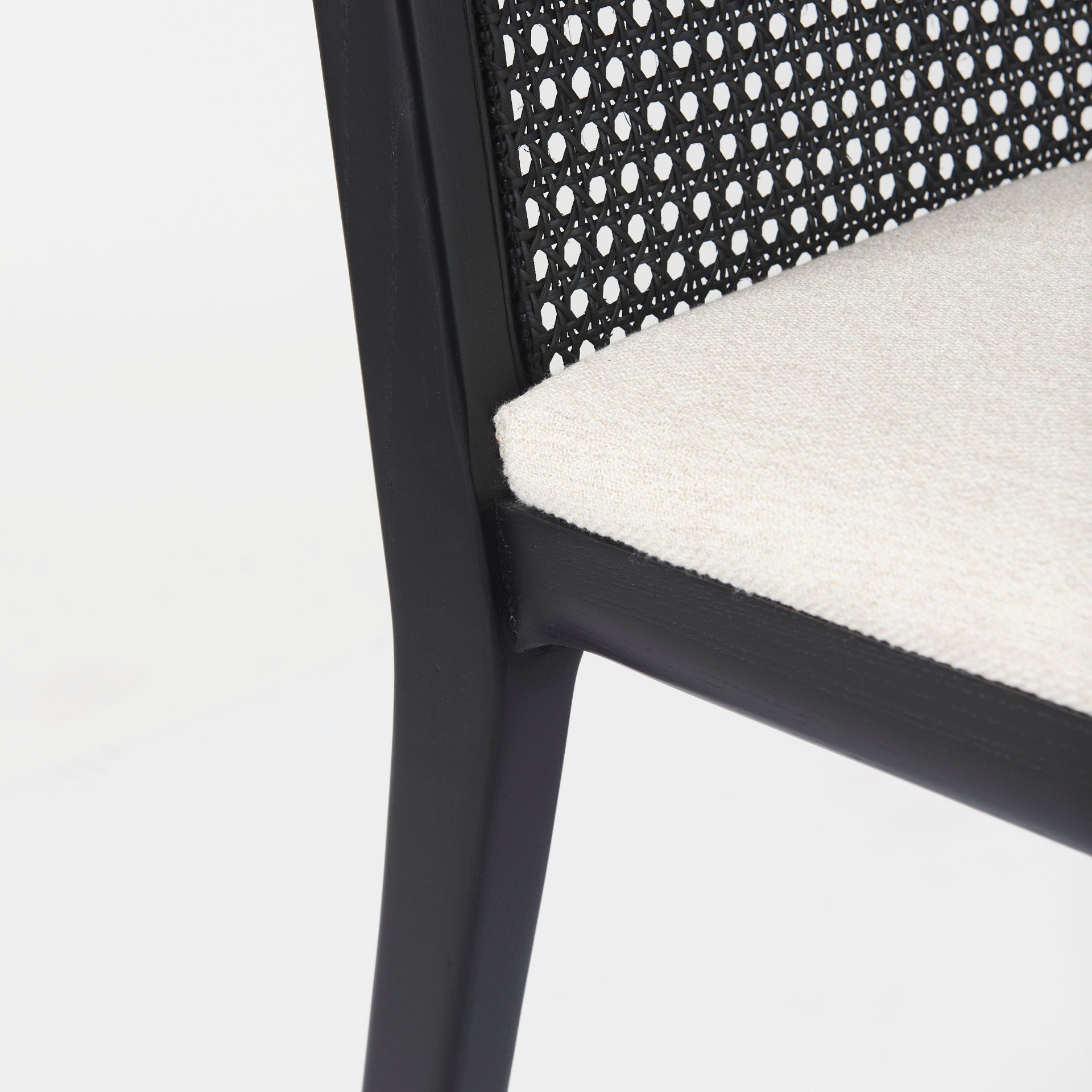 Close up of Clara Black Wood W/ Cream Fabric Seat and Cane Back Armless Dining Chair on a white background