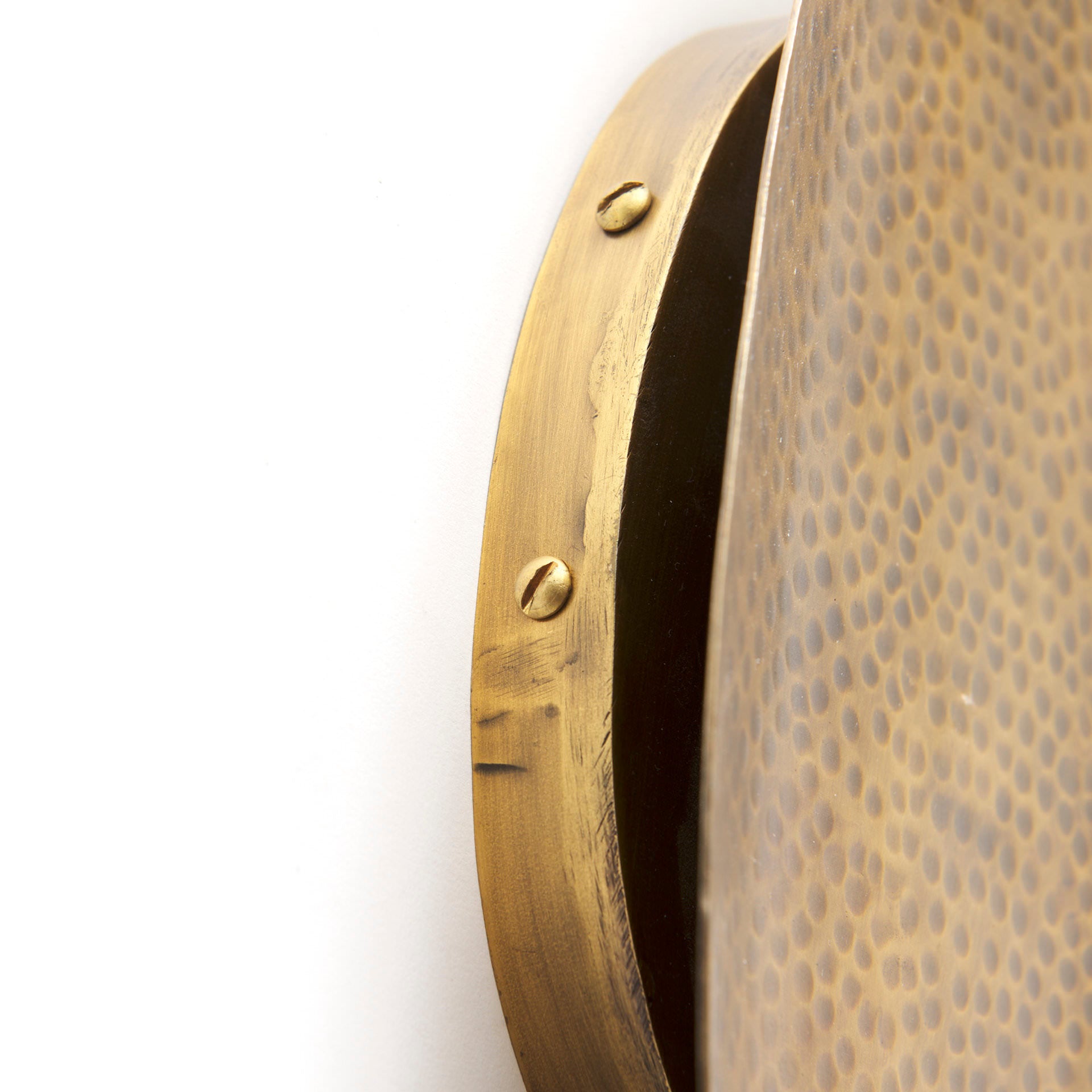 Close up of Clarence 7.0L x 5.3W x 17.0H Metal Hammered Gold Round Wall Sconce on a white background