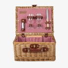 Wicker picnic basket with red checked interior and wine glasses on a white background