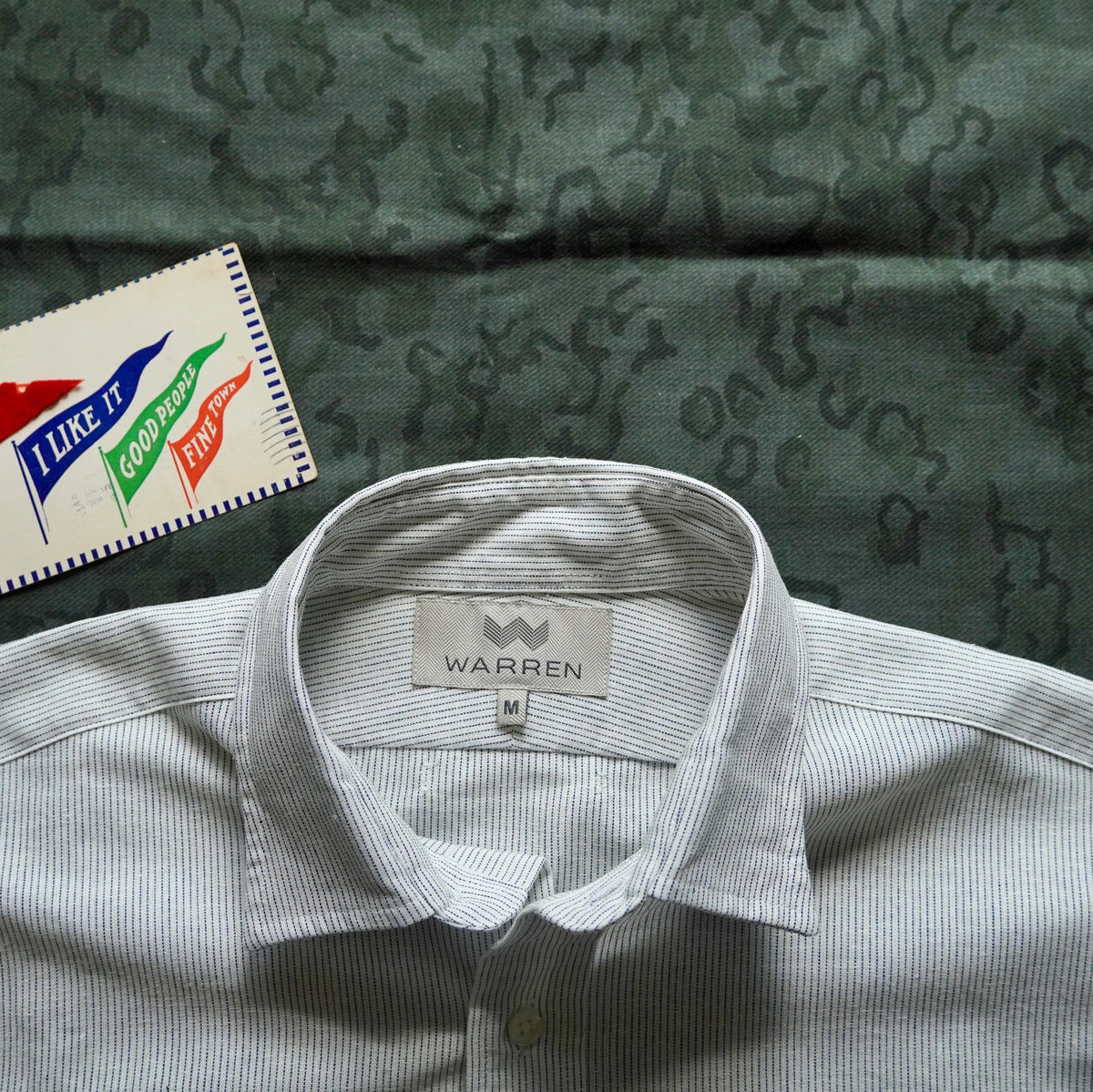 Warren Windsor Button Down in White Stripe on a green table at Addison West