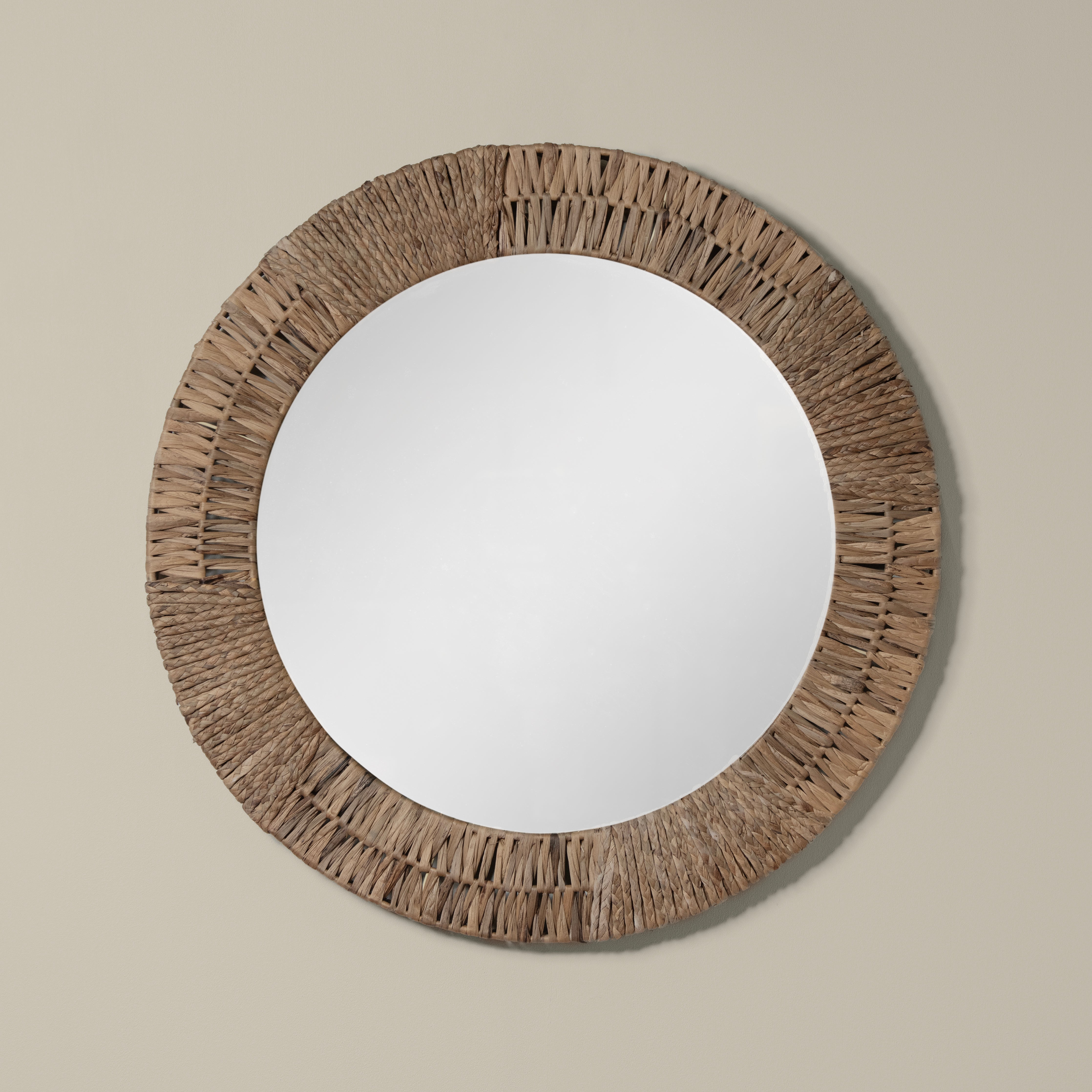 Folha Round Mirror in Natural on a beige background at Addison West