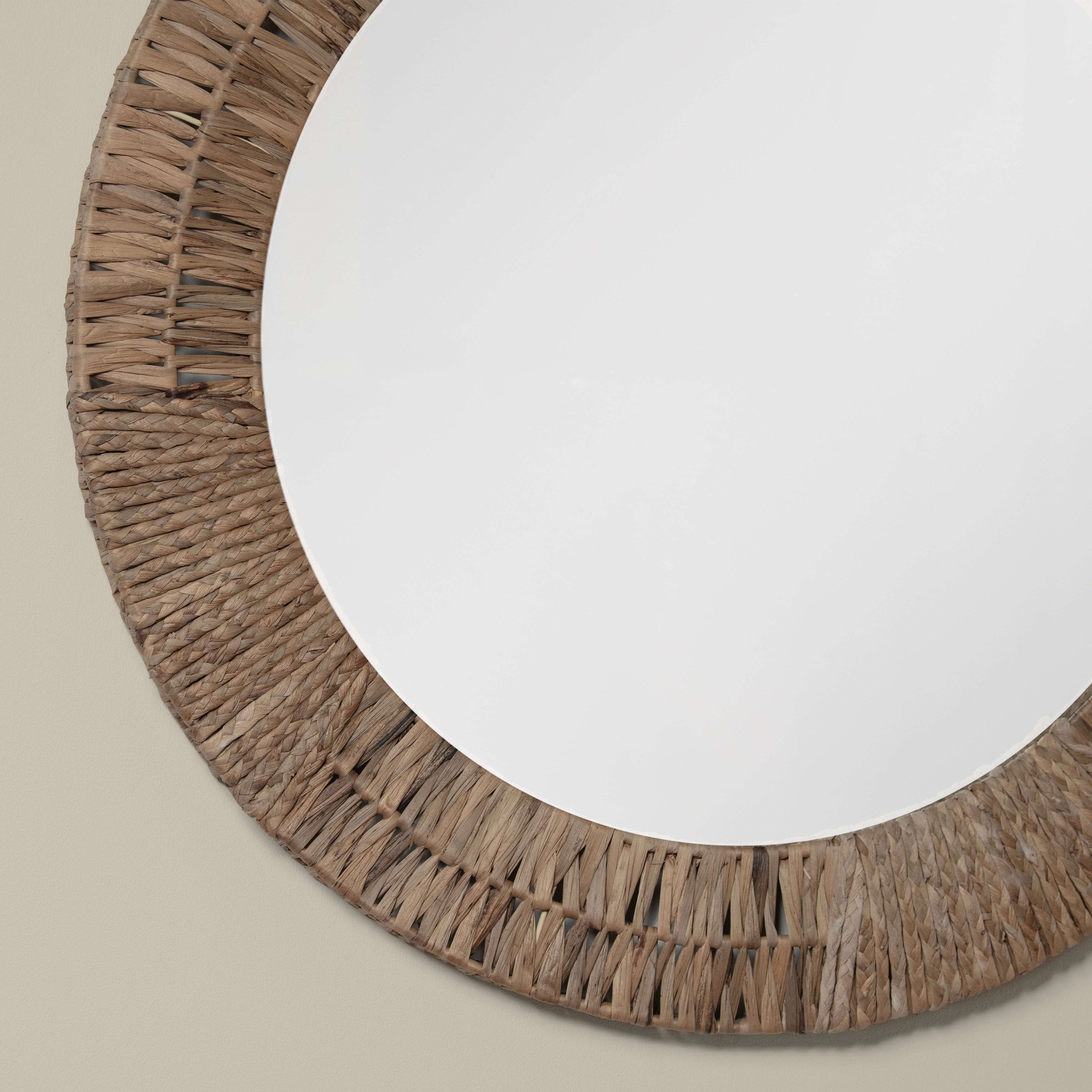 Close up of Folha Round Mirror in Natural on a beige background at Addison West