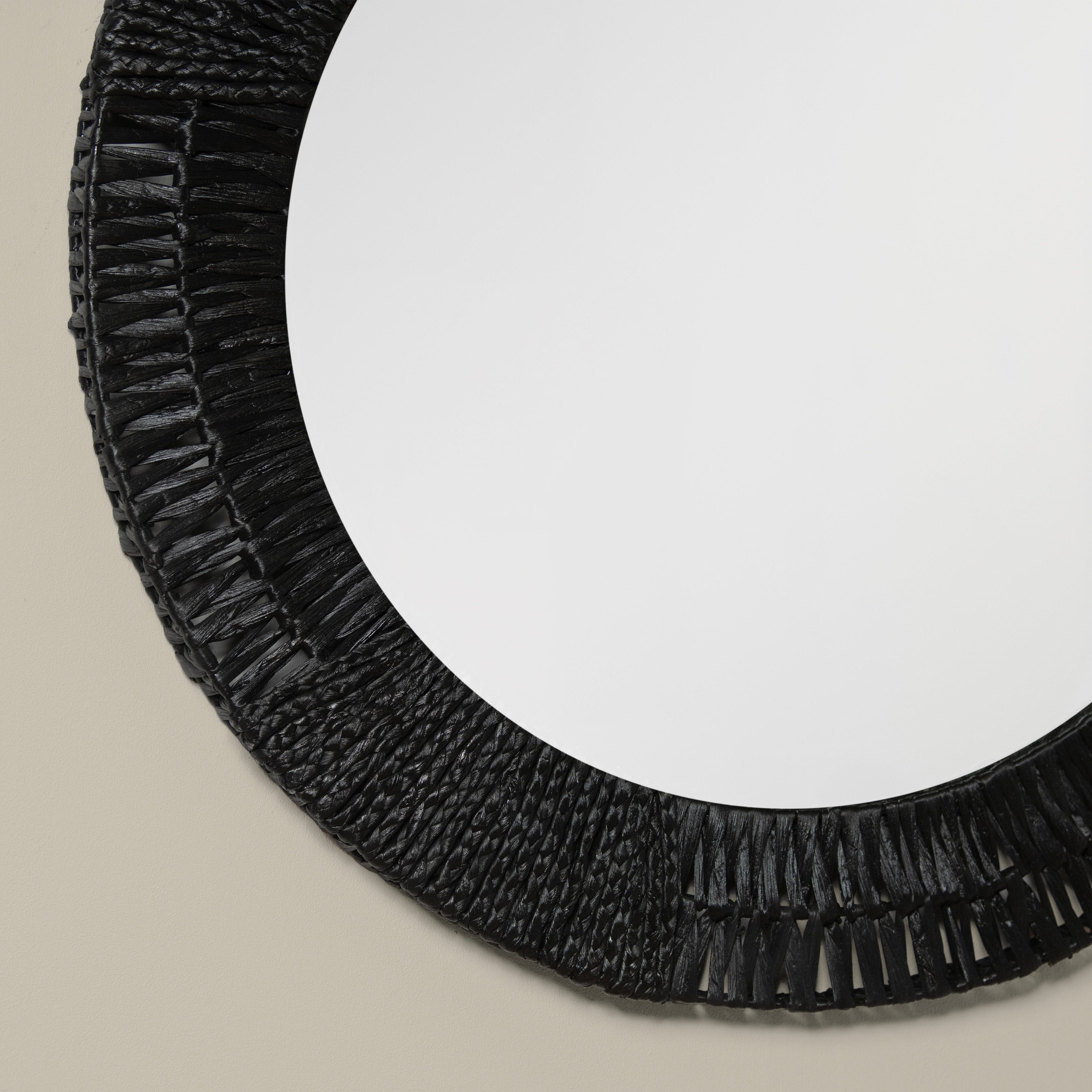 Close up of Folha Round Mirror in Black on a beige background at Addison West