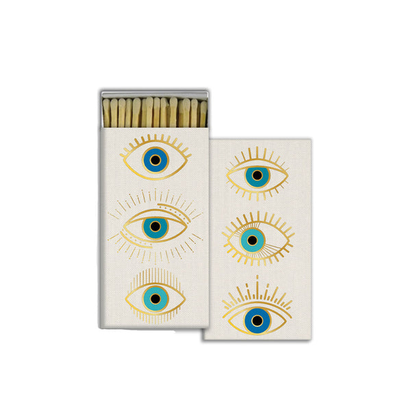 White Box of matches with three drawn eyes in gold and blue on a white background