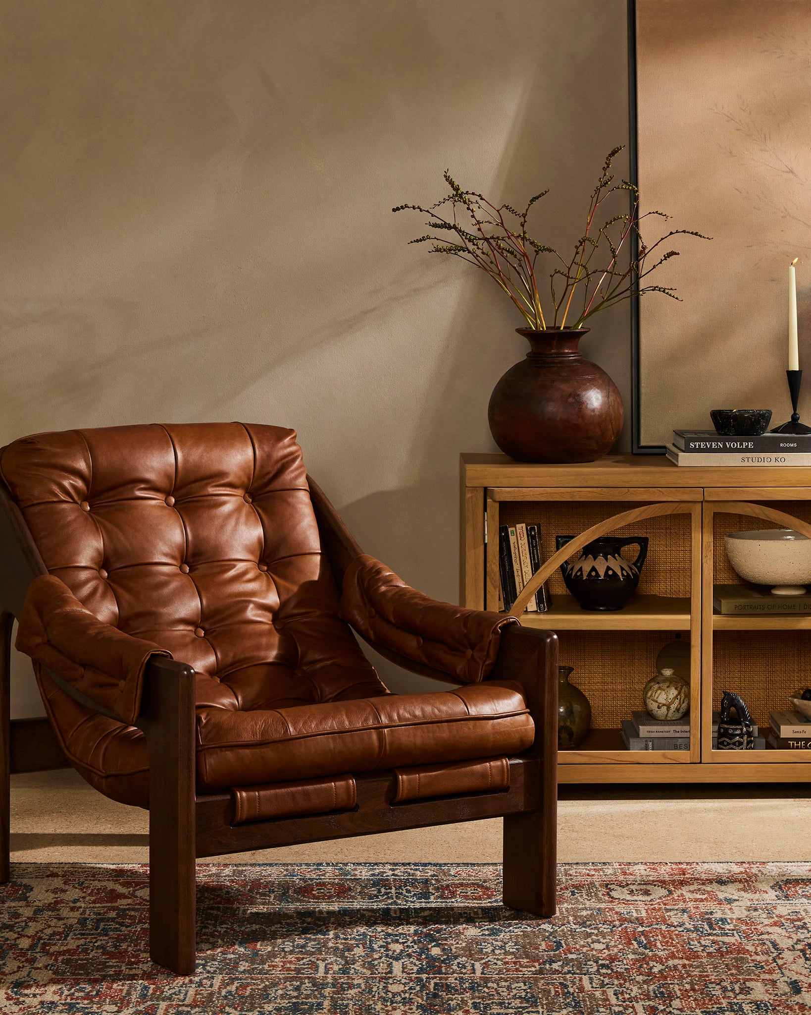 Four Hands Halston Chair In Heirloom Sienna in a living room with warm brown walls and a tribal rug