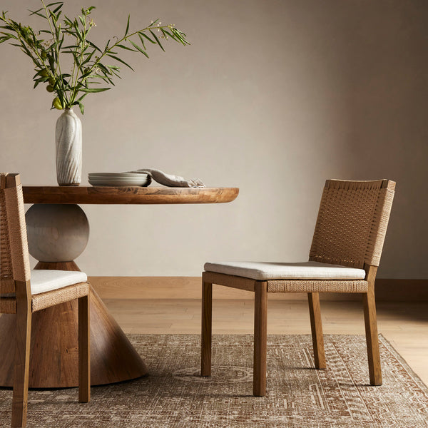 Four Hands Zuma Dining Chair with beige cushion and woven back in Dune Ash in a dining space