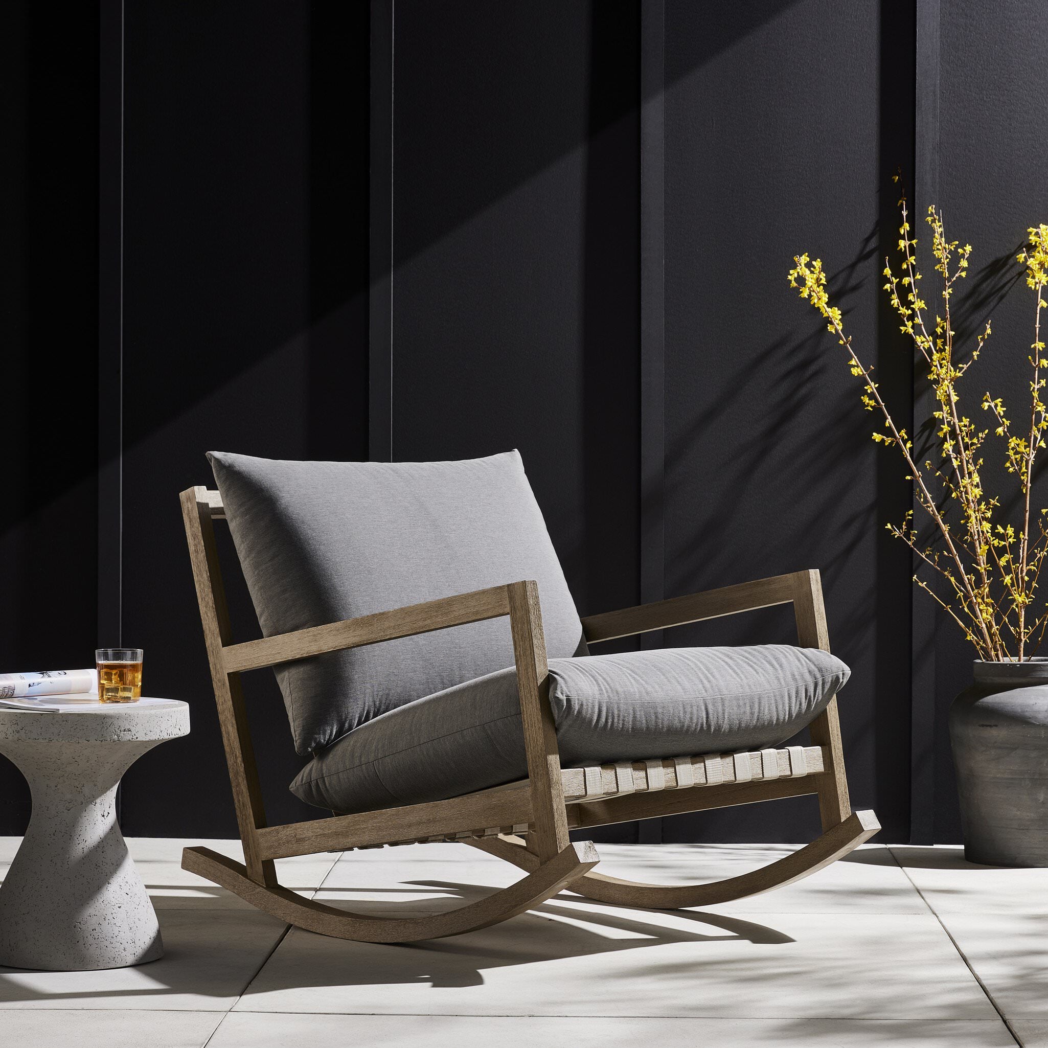 Four Hands Aiken Outdoor Rocking Chair in Venao Charcoal on a patio at Addison West