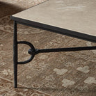 Close up of Four Hands Babylon Coffee Table in Lunar Marble against a rust rug at Addison West