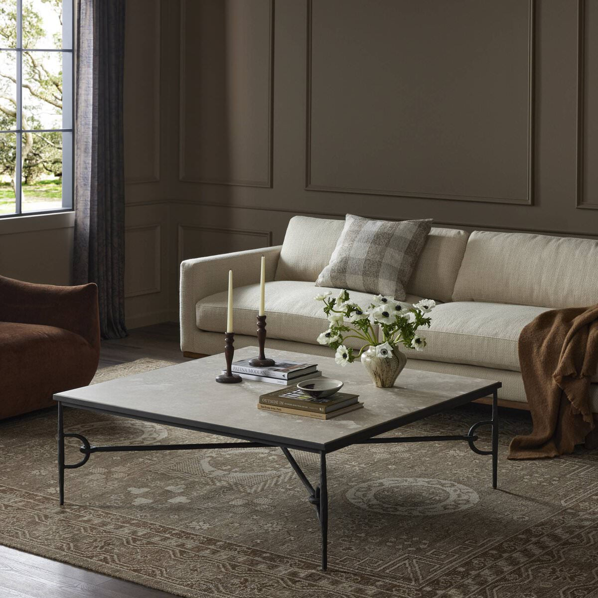 Four Hands Babylon Coffee Table in Lunar Marble in a dark green living room at Addison West