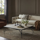 Four Hands Babylon Coffee Table in Lunar Marble in a dark green living room at Addison West