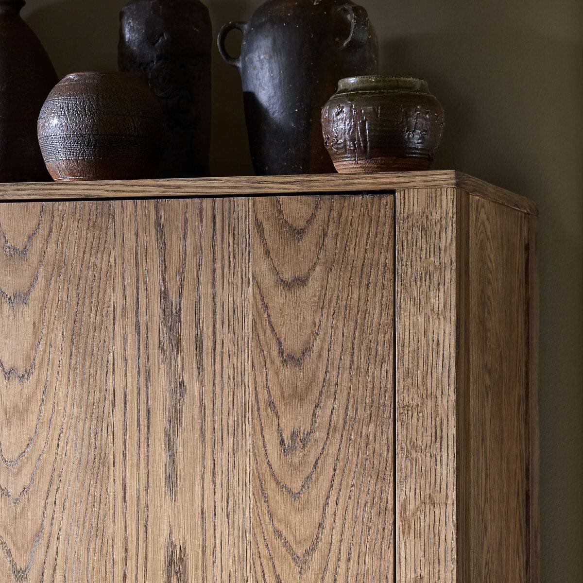 Close up of Four Hands Bedford Cabinet in Warm Natural Oak Veneer in a living room at Addison West