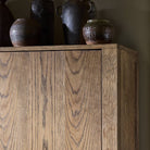 Close up of Four Hands Bedford Cabinet in Warm Natural Oak Veneer in a living room at Addison West