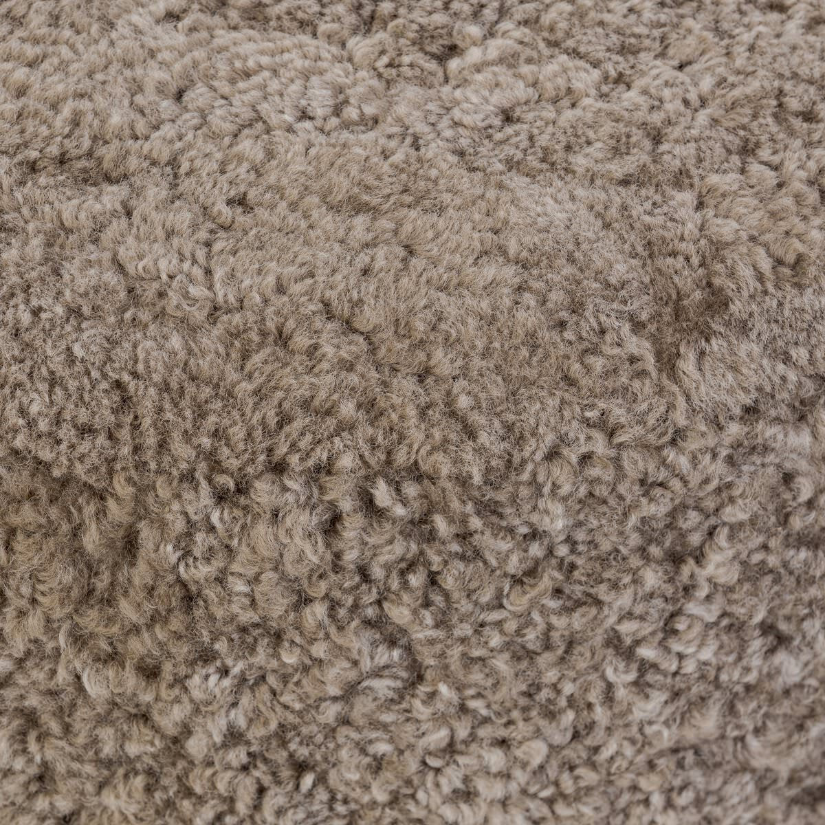 Close up of Four Hands Bilbury Ottoman in Taupe Shearling on a white background at Addison West