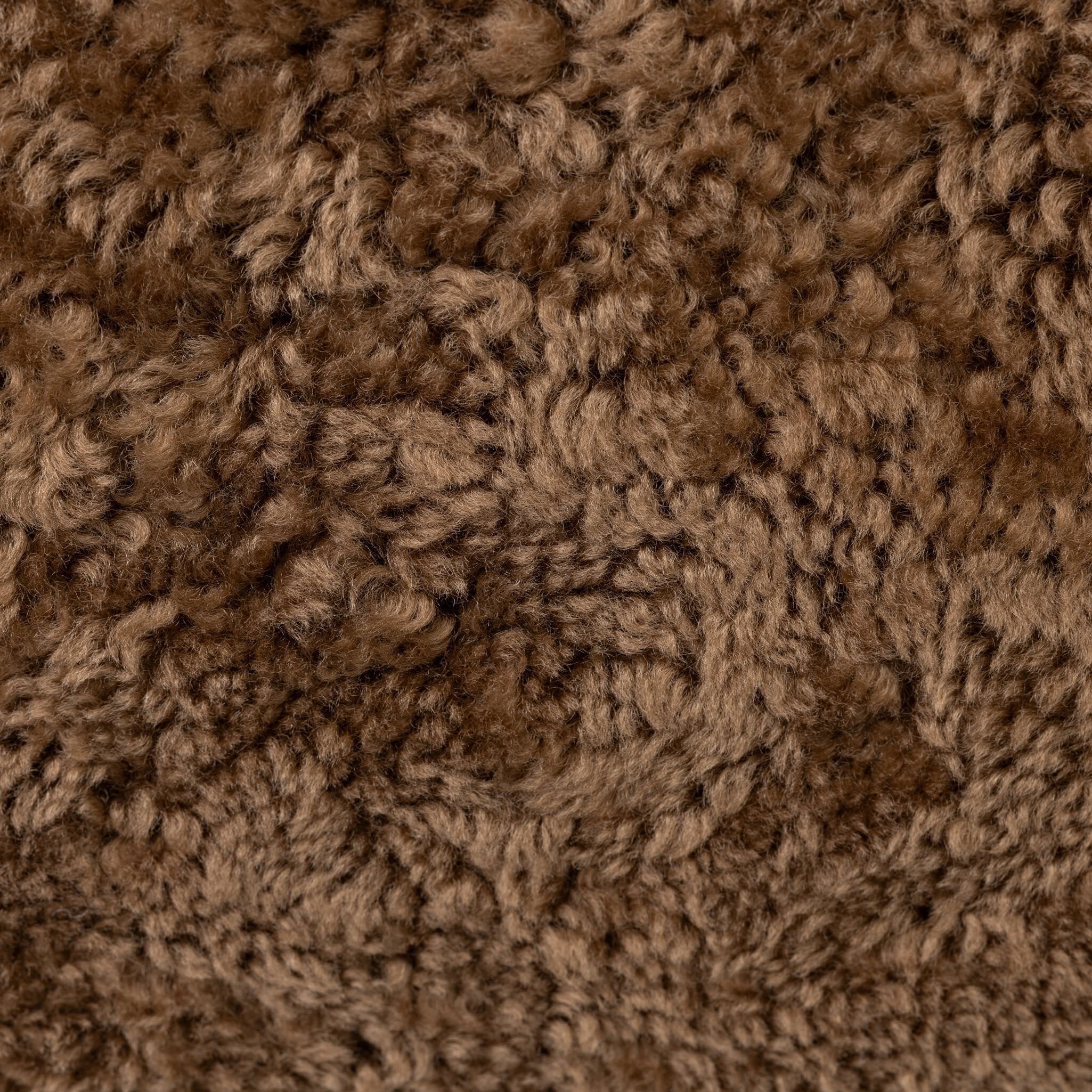 Four Hands Bilbury Oval Ottoman in Amber Shearling on white background at Addison West.