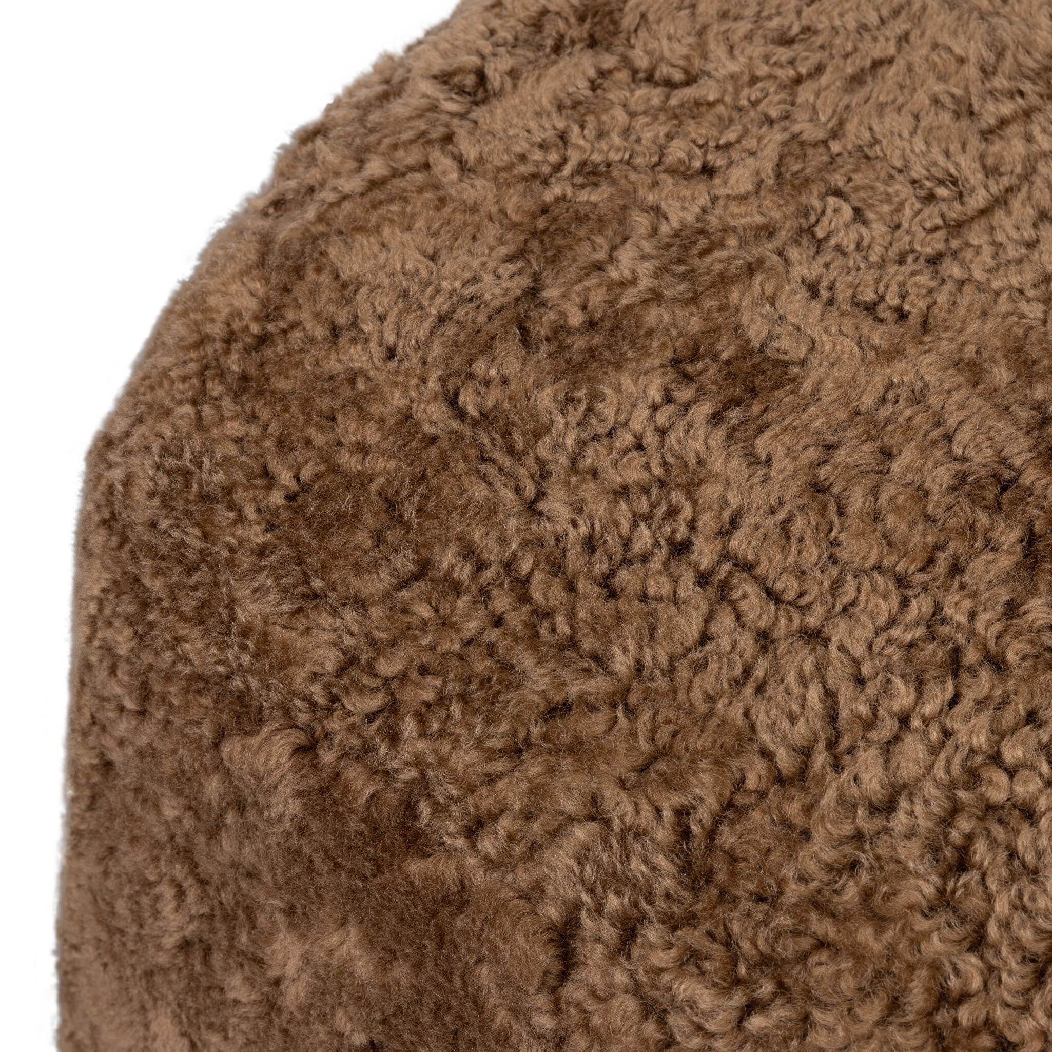 Four Hands Bilbury Oval Ottoman in Amber Shearling on white background at Addison West.