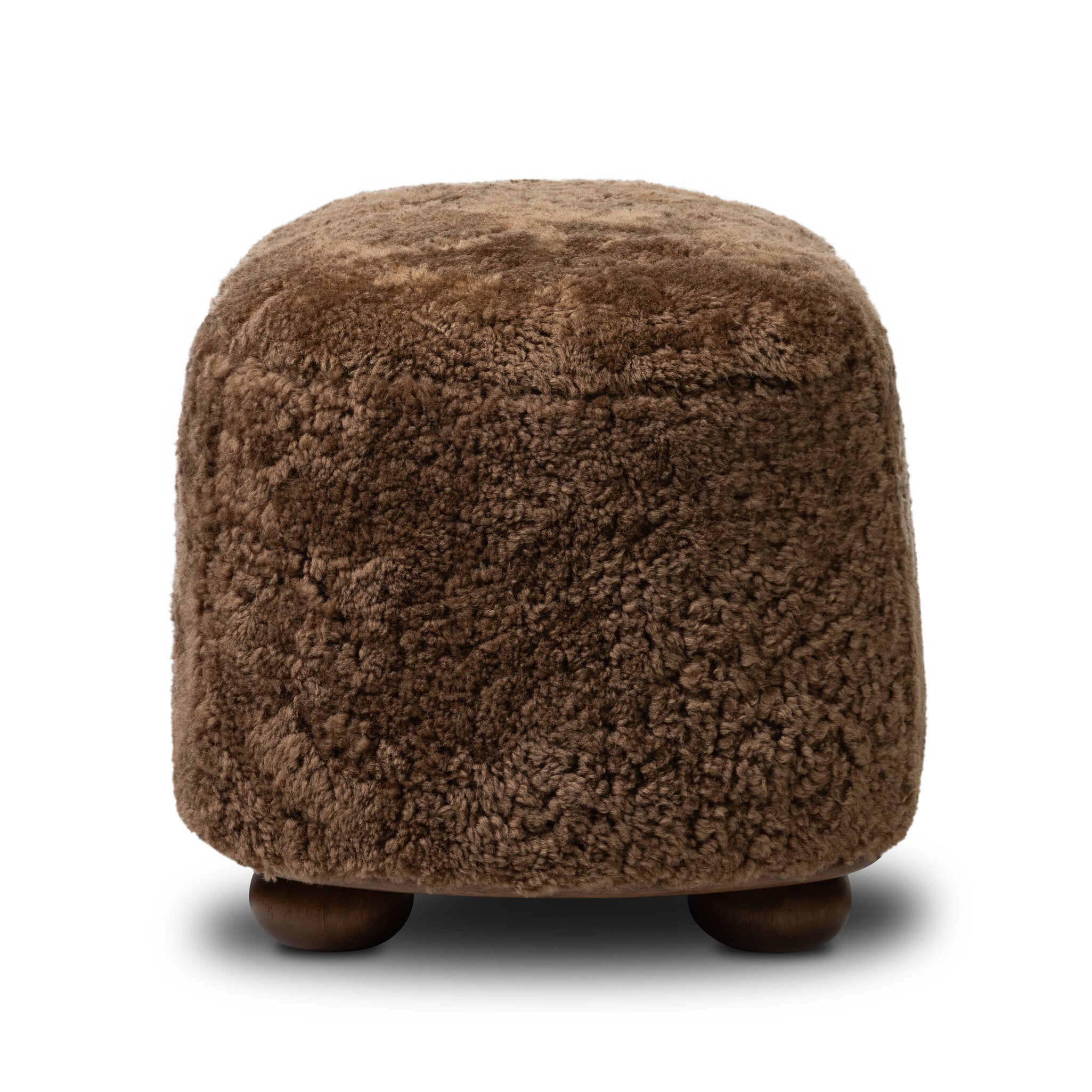Four Hands Bilbury Oval Ottoman in Amber Shearling on white background at Addison West.