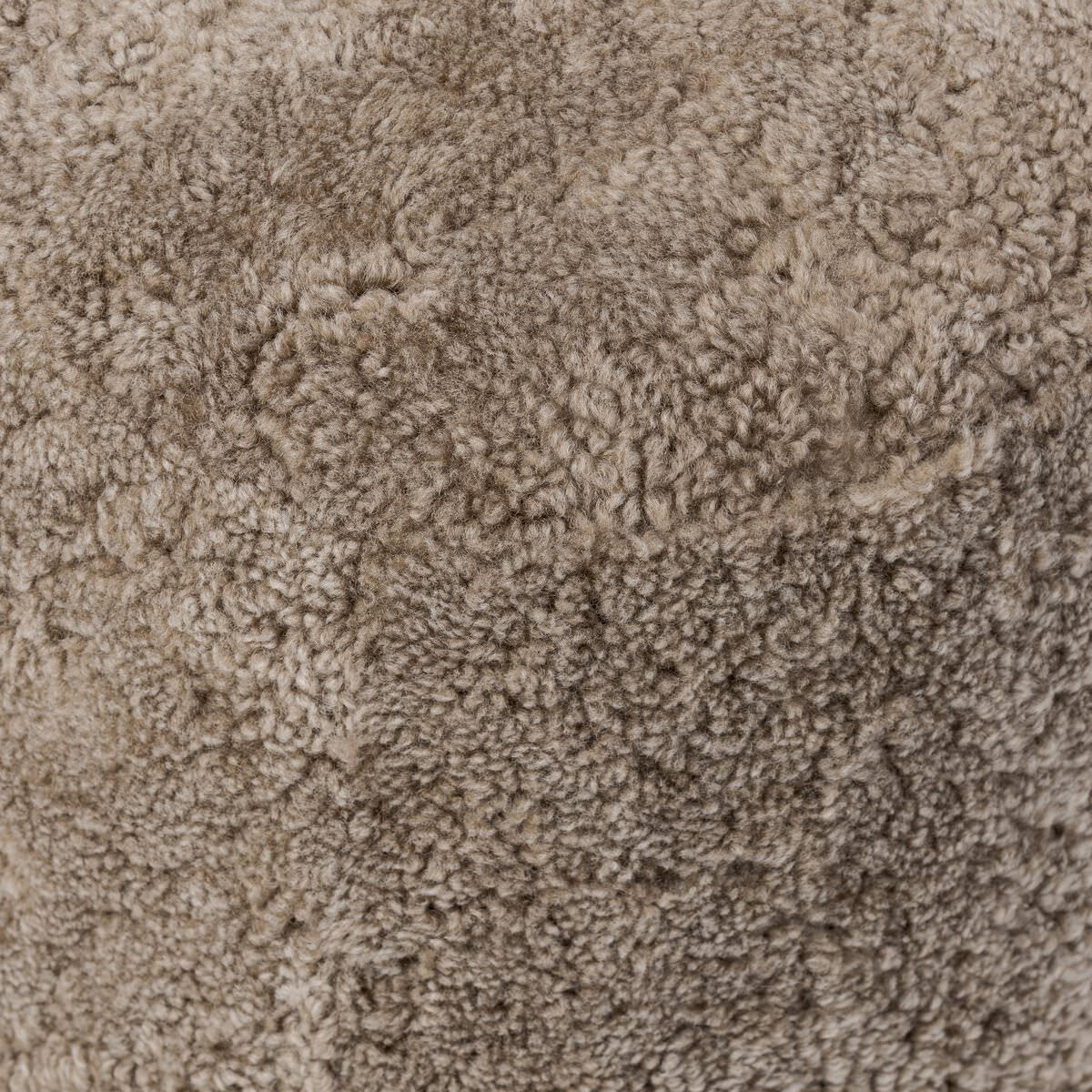 Close up of Four Hands Bilbury Oval Ottoman in Taupe Shearling on a white background at Addison West