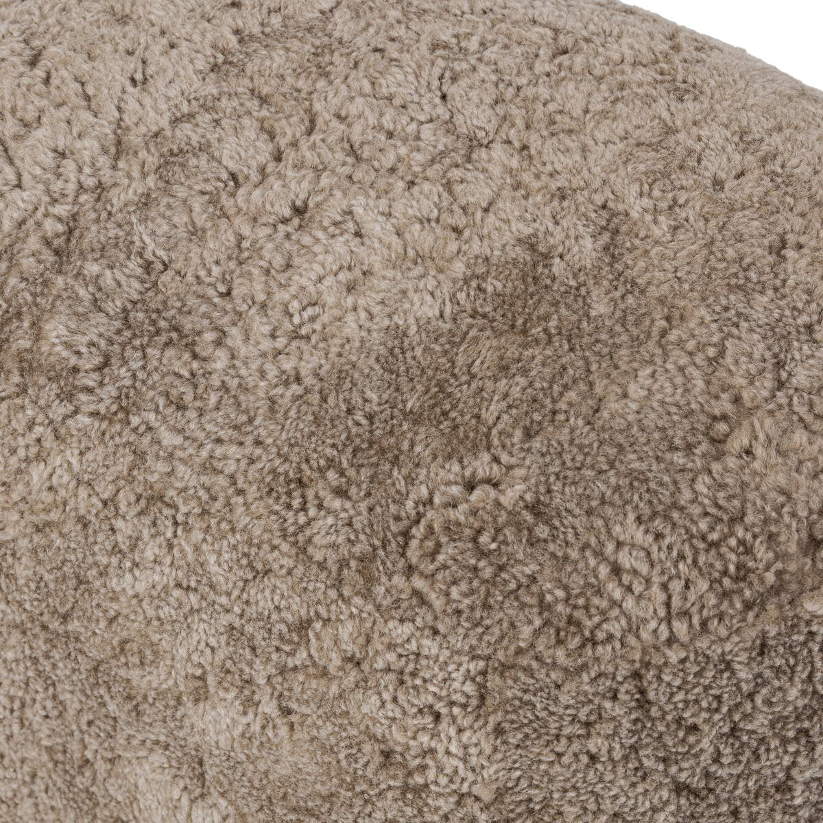 Close up of Four Hands Bilbury Oval Ottoman in Taupe Shearling on a white background at Addison West