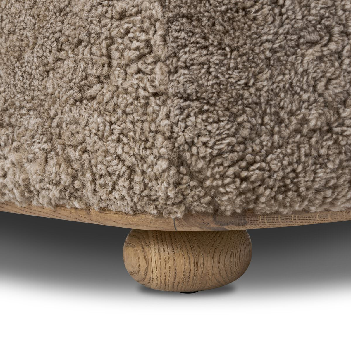 Close up of Four Hands Bilbury Oval Ottoman in Taupe Shearling on a white background at Addison West