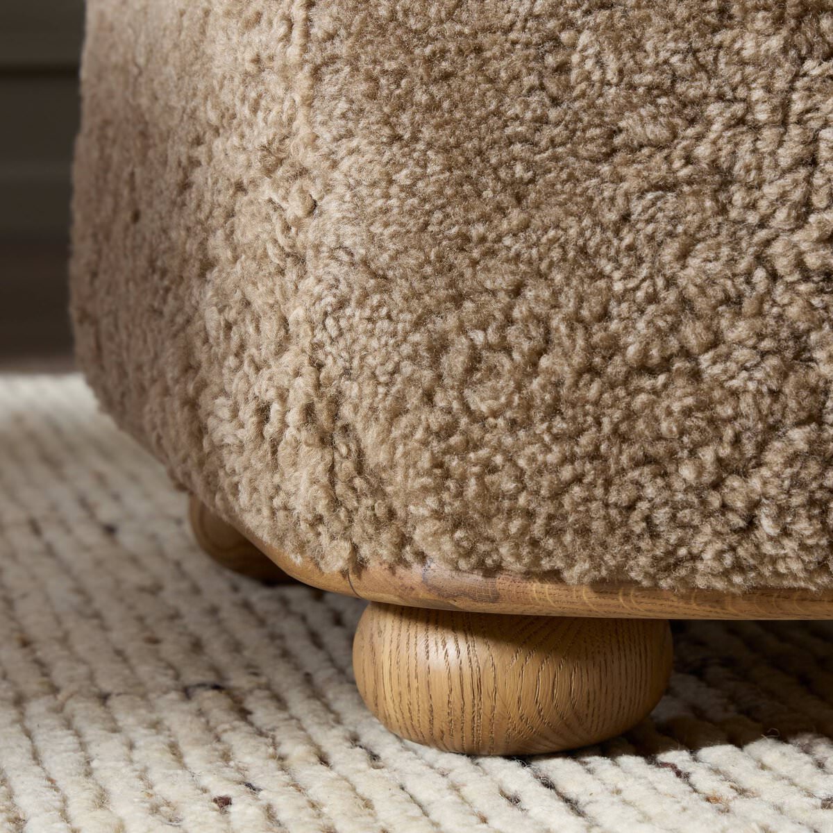 Close up of Four Hands Bilbury Oval Ottoman in Taupe Shearling on a white background at Addison West