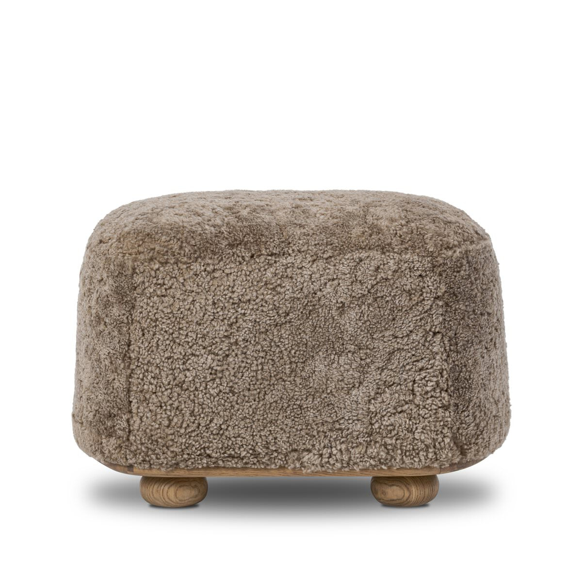 Four Hands Bilbury Oval Ottoman in Taupe Shearling on a white background at Addison West