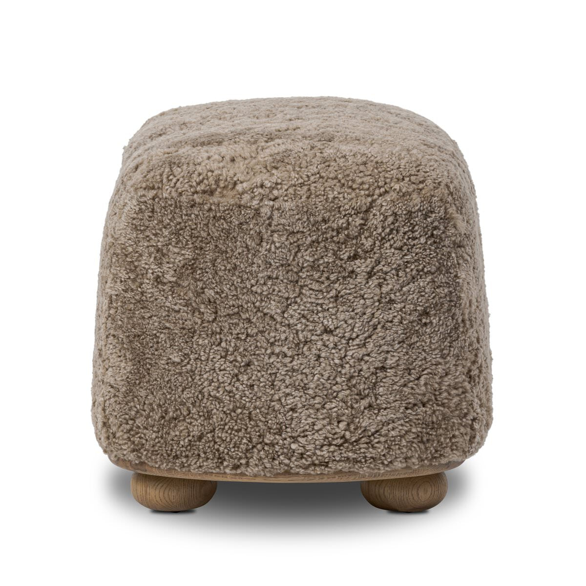 Four Hands Bilbury Oval Ottoman in Taupe Shearling on a white background at Addison West