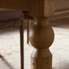 Close up of Four Hands Blinn Oval Leaf Extension Dining Table 88"-127" in Worn Oak Veneer on a white background at Addison West