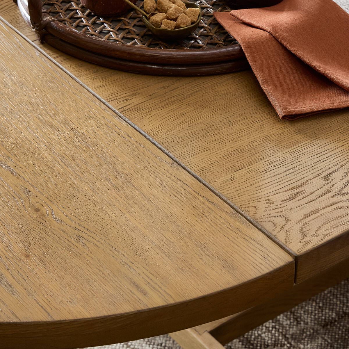 Close up of Four Hands Blinn Oval Leaf Extension Dining Table 88"-127" in Worn Oak Veneer in a dining room at Addison West