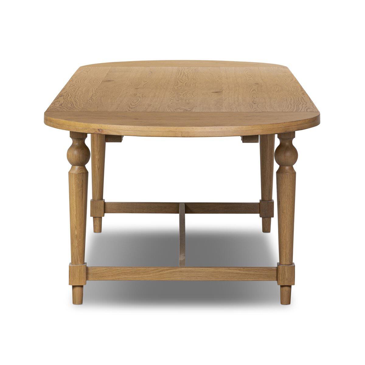 Four Hands Blinn Oval Leaf Extension Dining Table 88"-127" in Worn Oak Veneer on a white background at Addison West