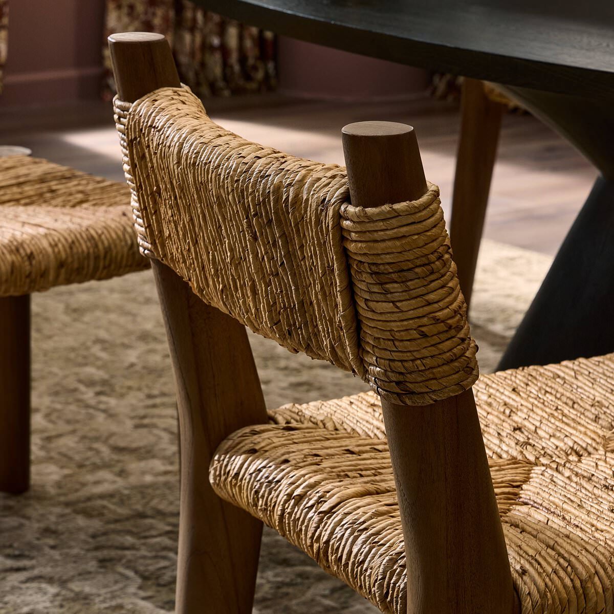 Close up of Four Hands Bovard Dining Chair in Stained Toasted Brown in a dining room at Addison West