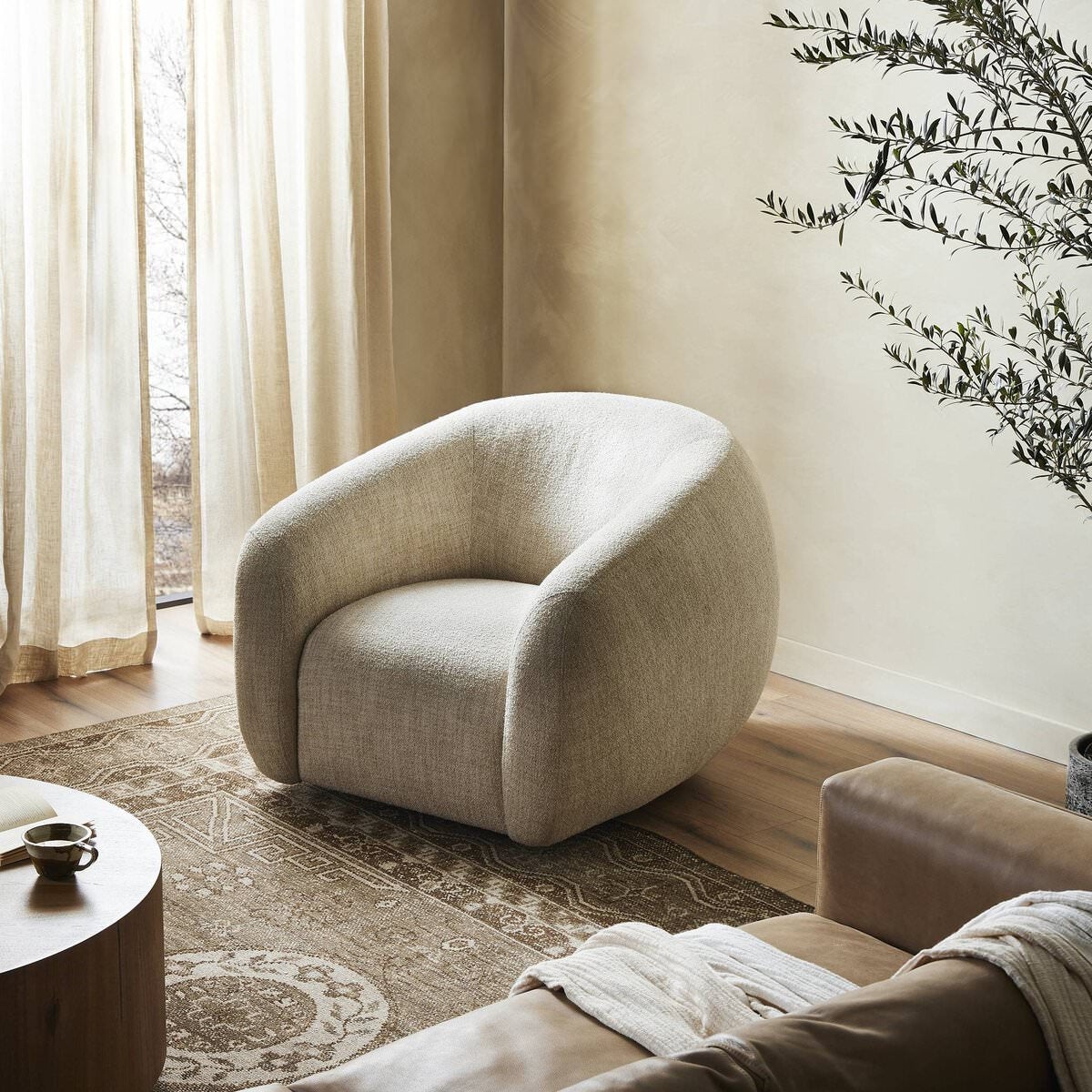 Four Hands Channing Swivel Chair in Yuma Cream in a living room at Addison West