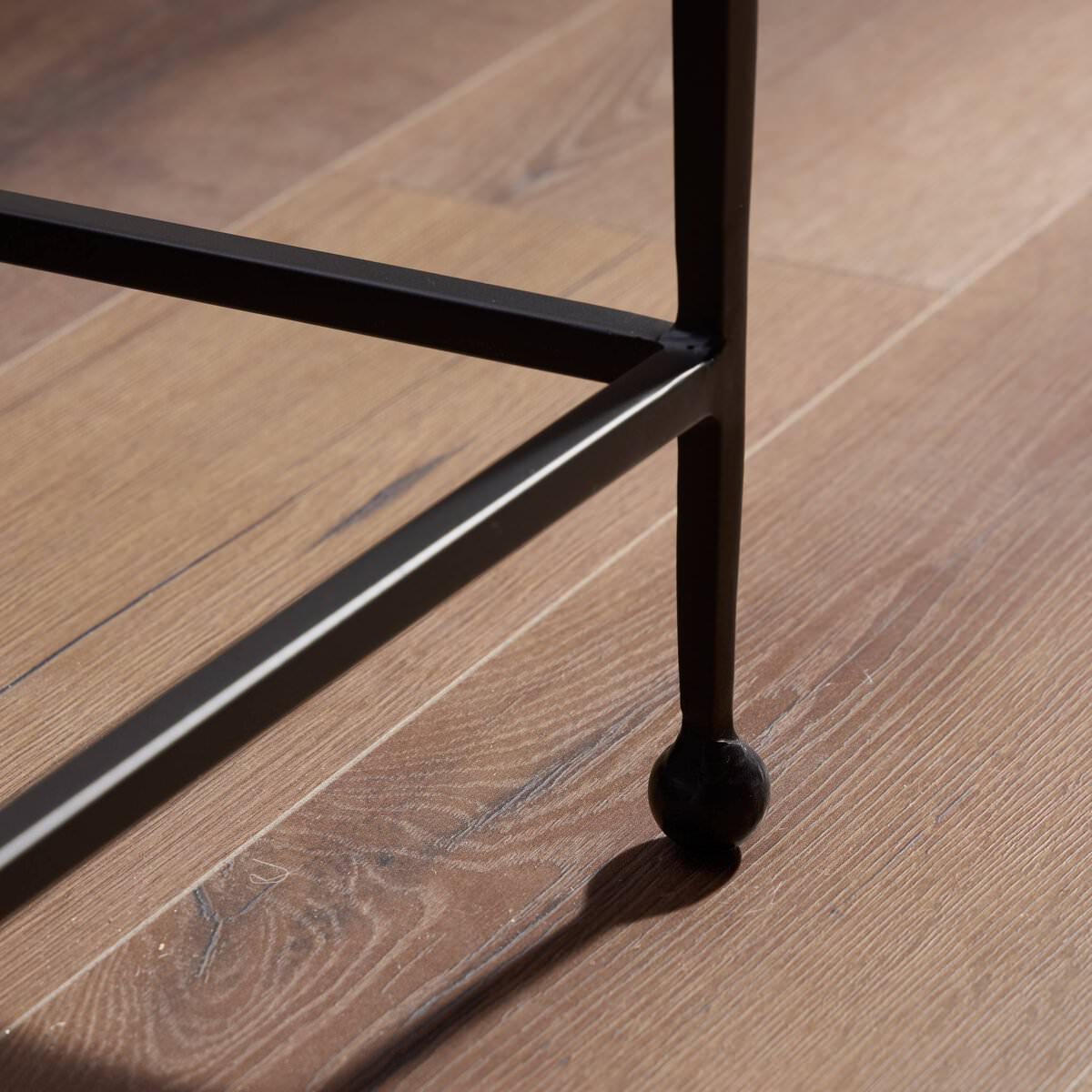 Close up of Four Hands Dalston Cast Glass Console Table in Smoked Black Cast Glass in a living room at Addison West