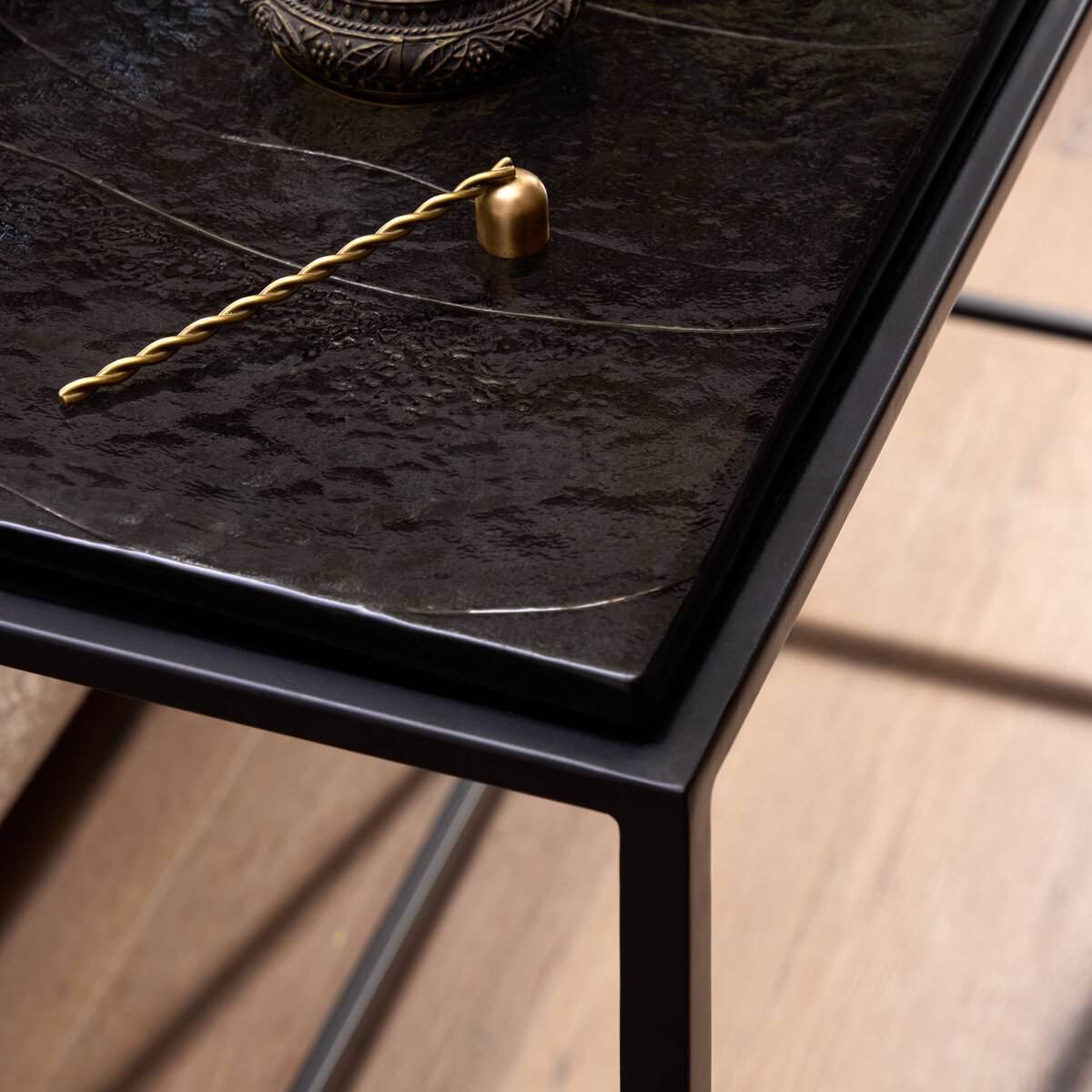Close up of Four Hands Dalston Cast Glass Console Table in Smoked Black Cast Glass in a living room at Addison West