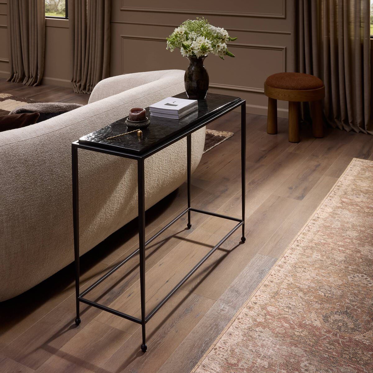 Four Hands Dalston Cast Glass Console Table in Smoked Black Cast Glass in a living room at Addison West