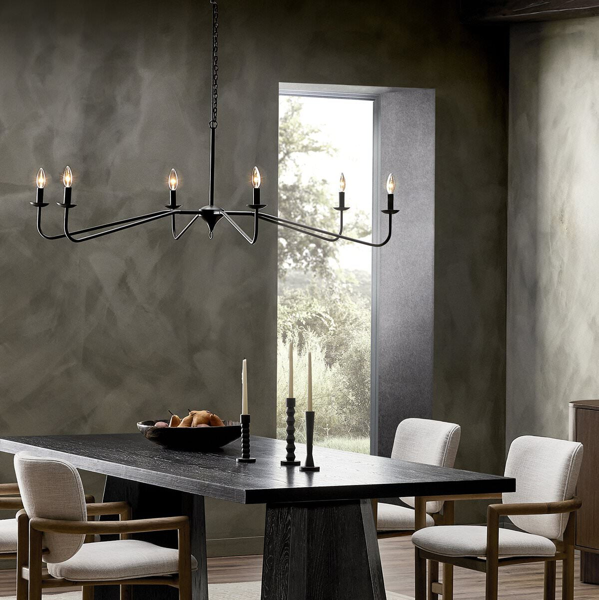 Four Hands Edlyn Chandelier in Antiqued Iron in a modern dark dining room with