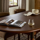 Close up of Four Hands Harper Oval Extension Dining Table 84-104" in Toasted Walnut in a traditional living room at Addison West