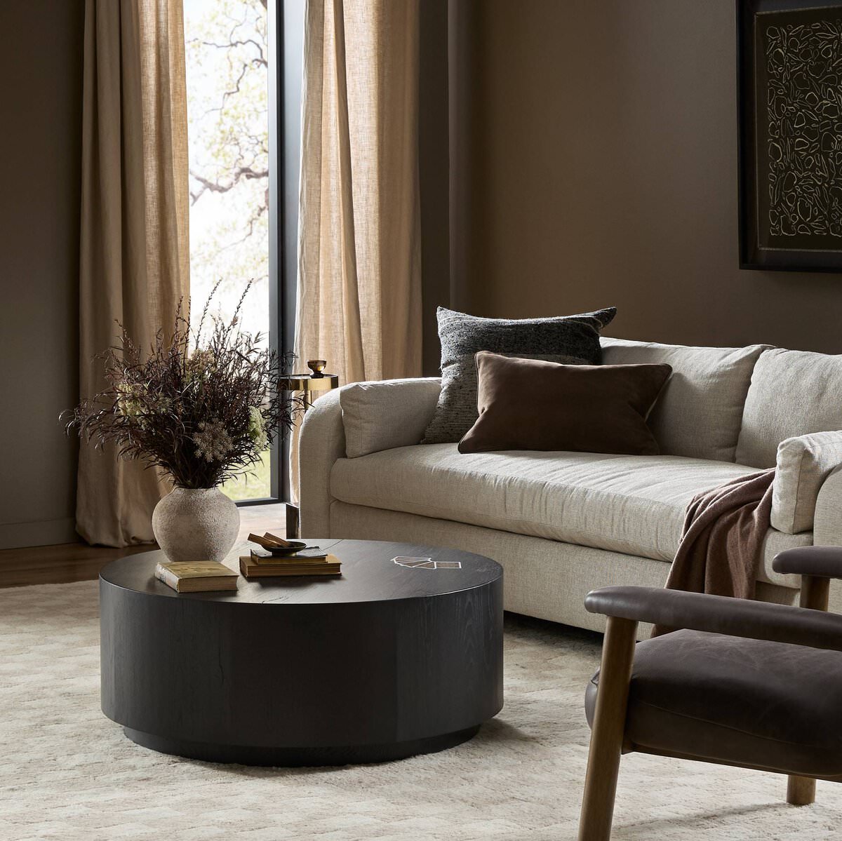 Four Hands Humphrey Round Coffee Table in Coal on Oak in a neutral living room at Addison West