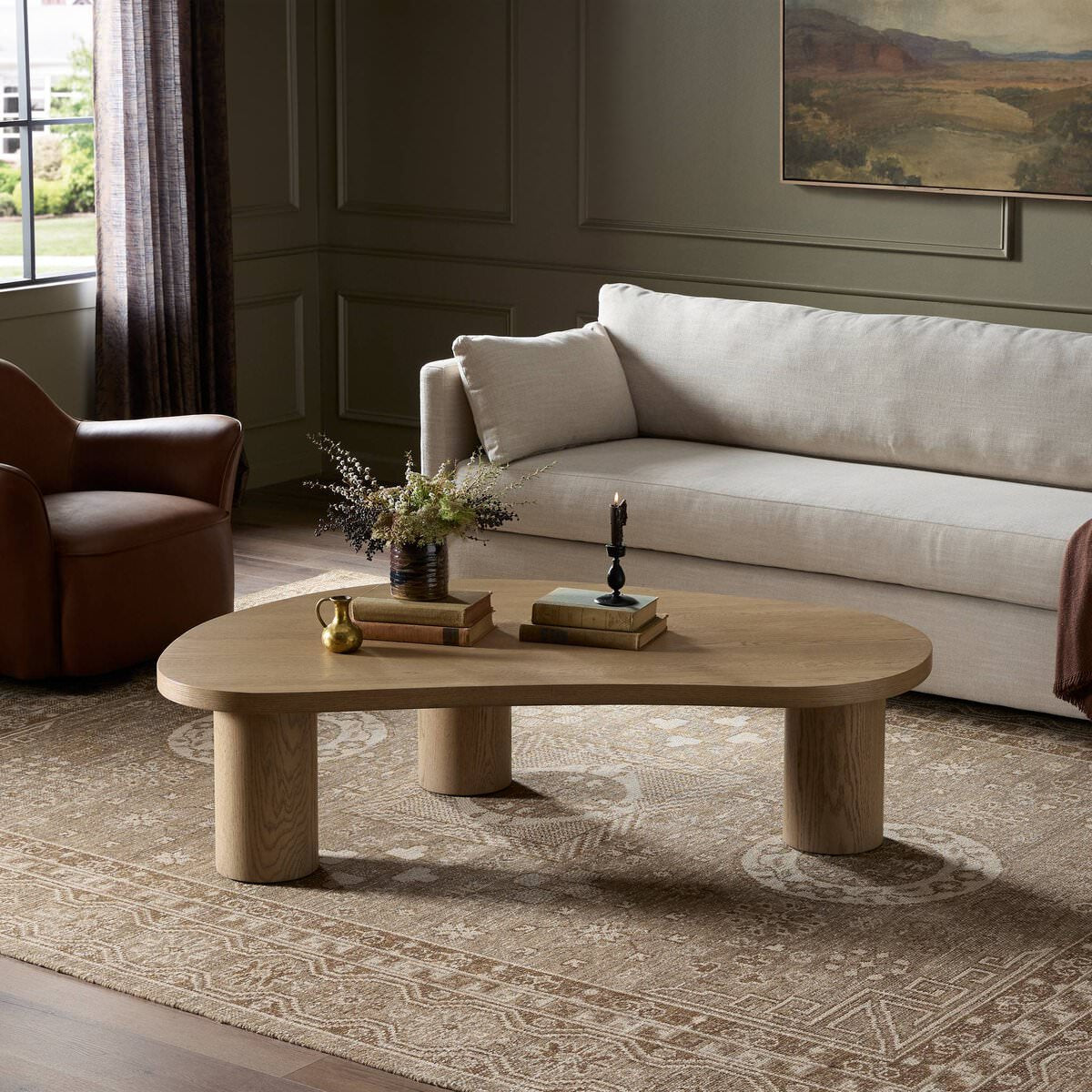 Four Hands Joji Nesting Coffee Table in Natural Oak Veneer in Large in a living room with green walls at Addison West