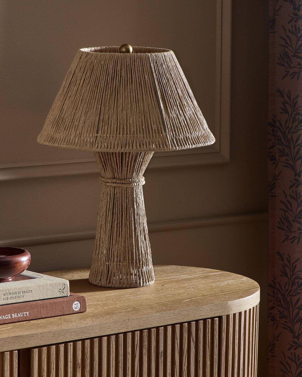 Four Hands Nessa Table Lamp in Antique Brass Iron on a table at Addison West