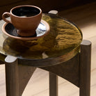 Close up of Four Hands Relo End Table in Olive Cast Glass in a living room at Addison West