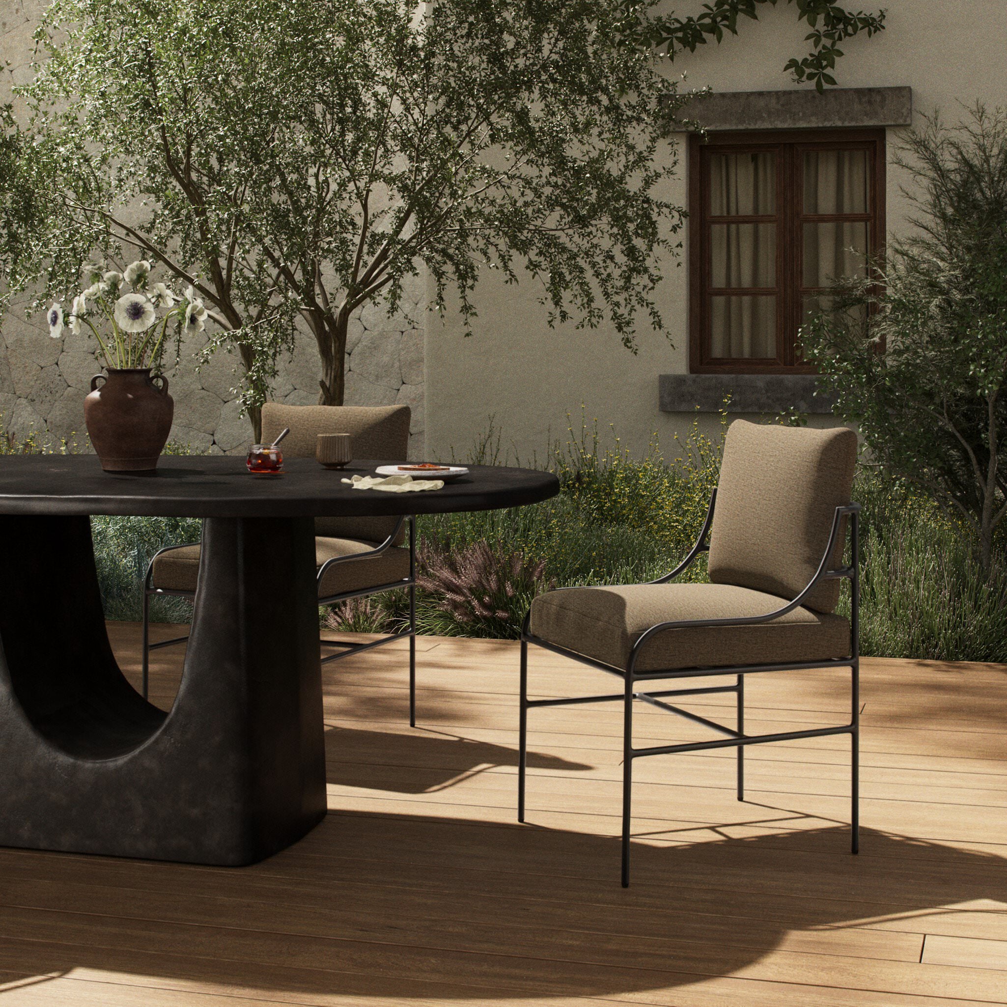 Four Hands Segovia Outdoor Dining Chair in Alessi Fawn on a patio at Addison West