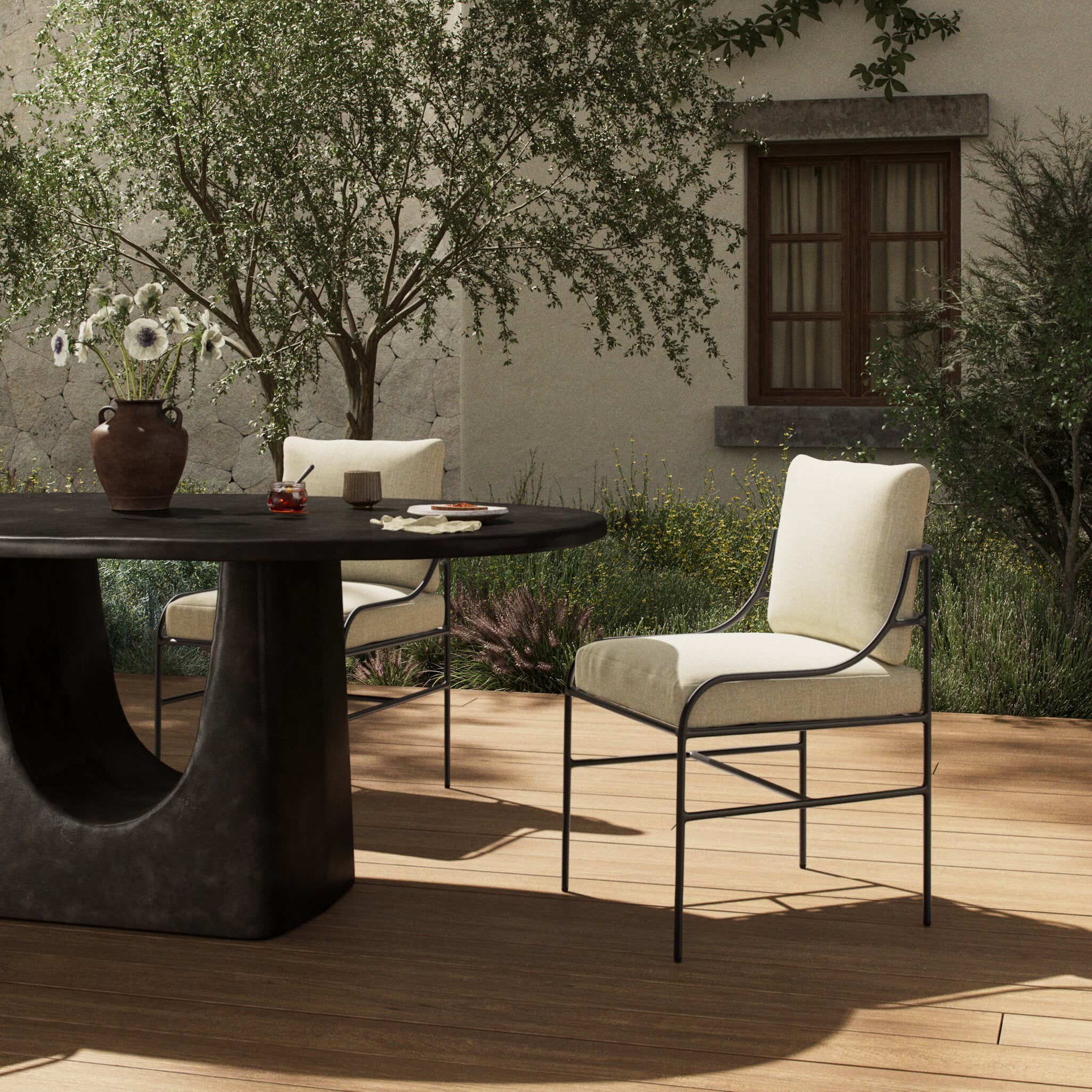 Four Hands Segovia Outdoor Dining Chair in Vergo Cream on a patio at Addison West