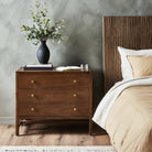 Four Hands Sullivan Nightstand in Saddle Tan Veneer in a modern bedroom with dark walls