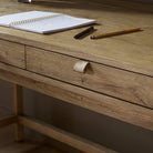 Close up of Four Hands Tula Writing Desk in Worn Oak Veneer on a white background at Addison West