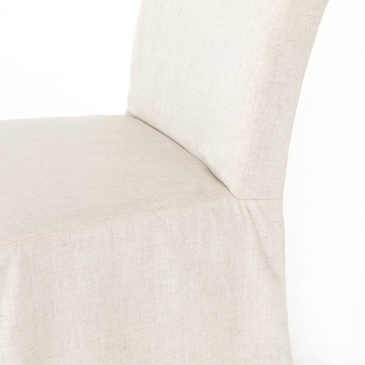 Close up of Four Hands Vista Slipcovered Dining Chair in Savile Flax on a white background